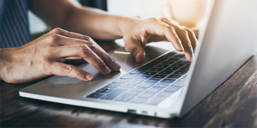 Photo of someone using a computer to fill out a form